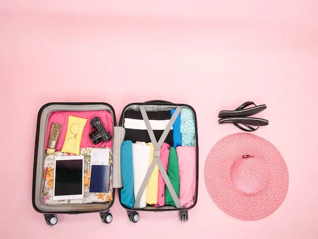 Neatly packed suitcase and pink hat