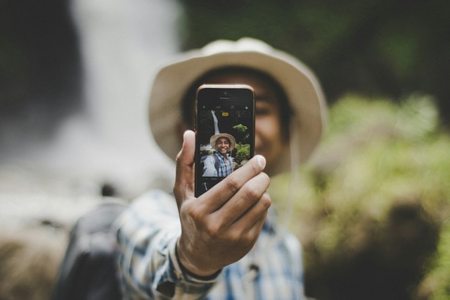 Man wearing a hat and taking a photo